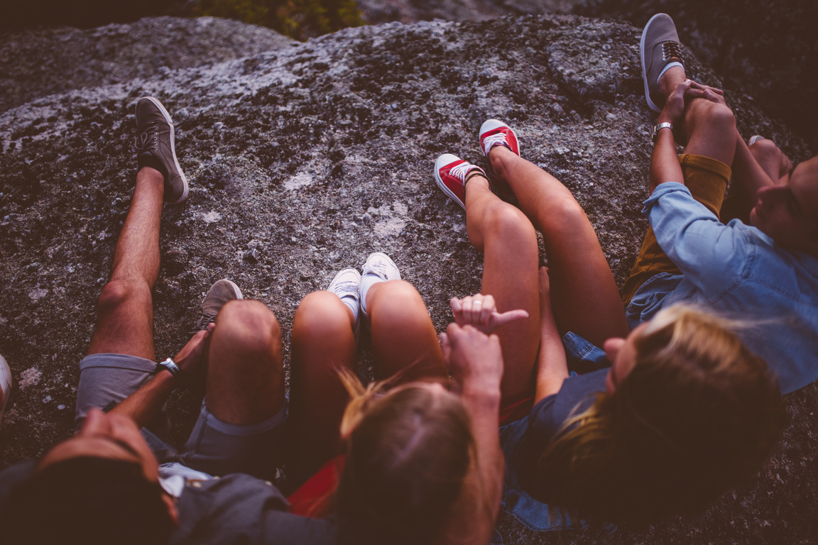 Legs of teenagers sitting outdoors together
